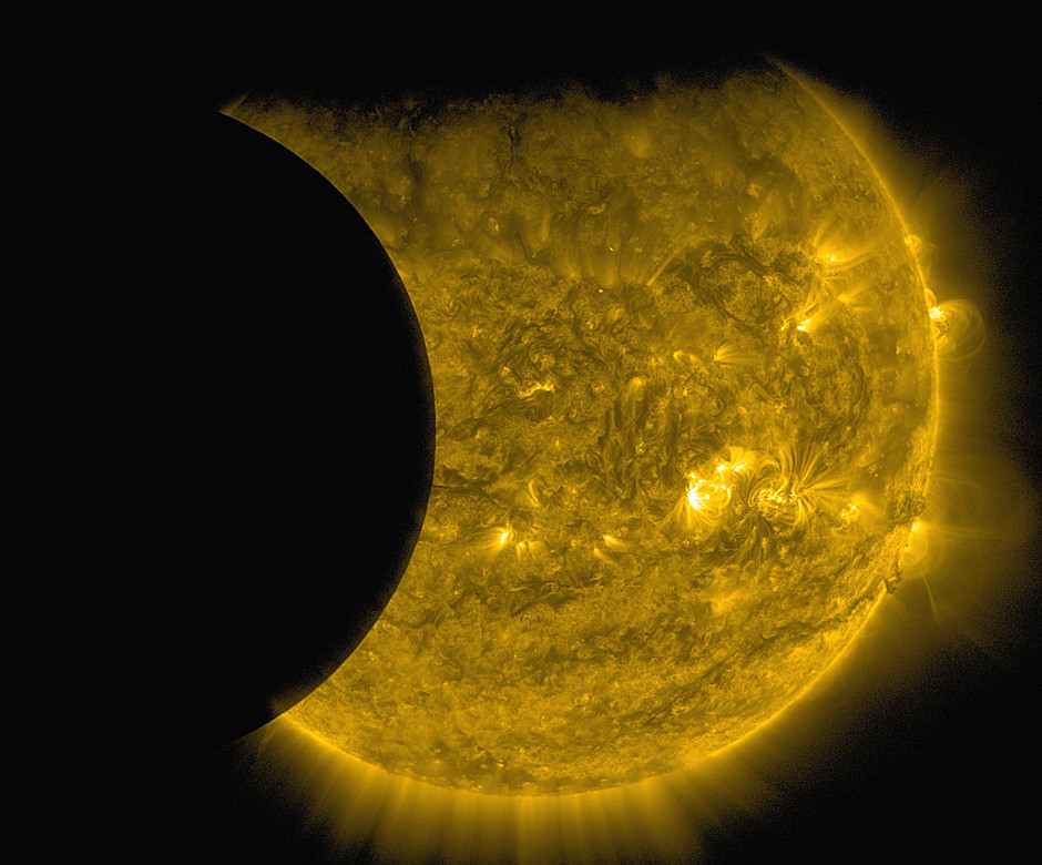 NASA’s Solar Dynamics Observatory captured this image of Earth and the Moon transiting the Sun together on 13 September 2015. The edge of Earth visible near the top of the frame appears fuzzy because Earth’s atmosphere blocks different amounts of