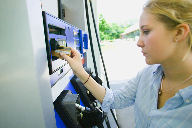 Teenage Girl Using Credit Card at Gas Station