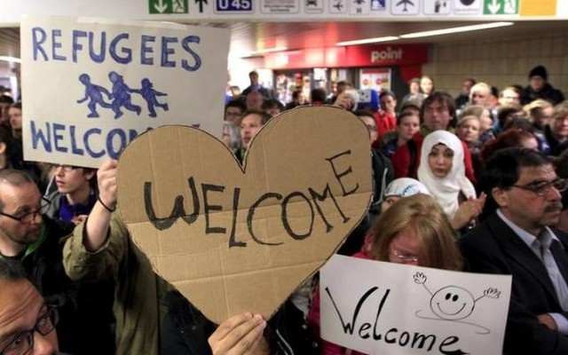 Wellwishers wave to migrants arriving at the main railway station in Dortmund Germany