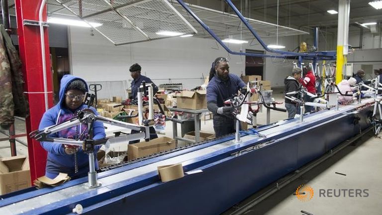 Workers operate the first assembly line started at the new Bicycle Corporation of America plant in Manning South Carolina USA