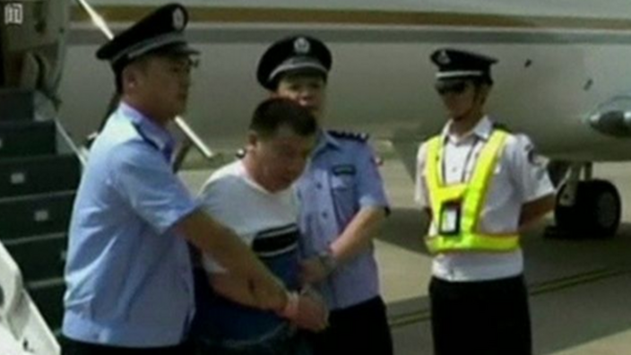 Yang Jinjun in handcuffs arriving in China 
    
    
                
          
          Show Grid