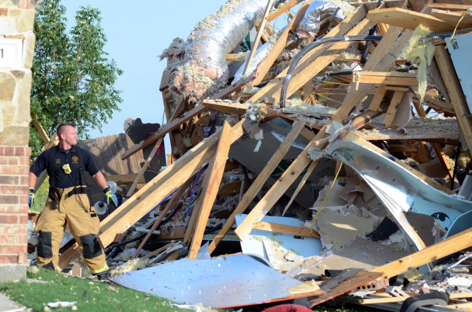 Emergency personnel walk around a house that exploded on Monday Sept. 21 2015 in Waxahachie Texas. A couple people were airlifted to a hospital after the explosion