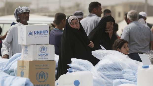 Iraqis internally displaced wait for humanitarian aid being distributed at a refugee camp in Baghdad's western neighborhood of Ghazaliyah Iraq last week
