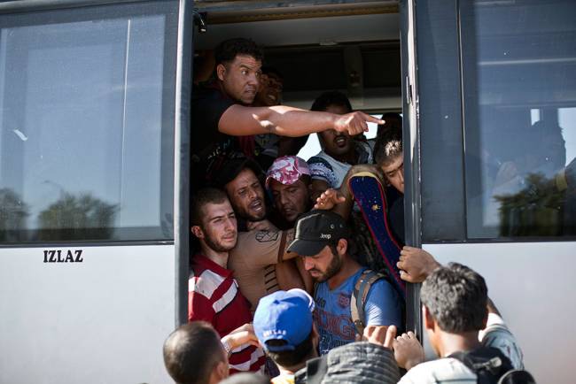 People crowd a bus provided by the Croatian government after pushing through police lines in Tovarnik Croatia Thursday Sept. 17 2015