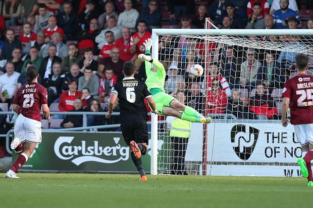 Adam Smith of Northampton Town dives in vain as he is beaten by a free kick taken by Dean Cox