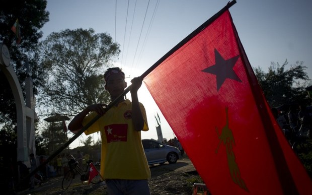 A National League for Democracy supporter holds the party flag