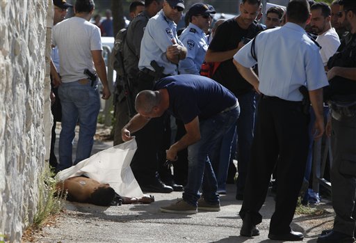 Israeli police stand around the body of a Palestinian in Jerusalem Saturday Oct. 17 2015. Police spokeswoman Luba Samri said a 16-year-old Palestinian drew a knife on officers when they approached him in Jerusalem and asked for identification Saturday