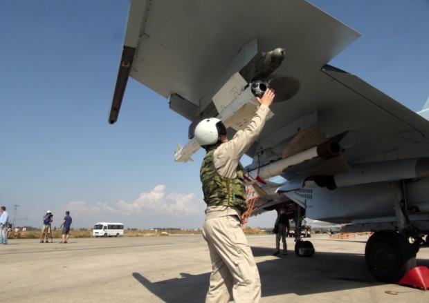 A Russian pilot checks a missile on his Su-30 warplane at a base in Syria on Monday before a sortie