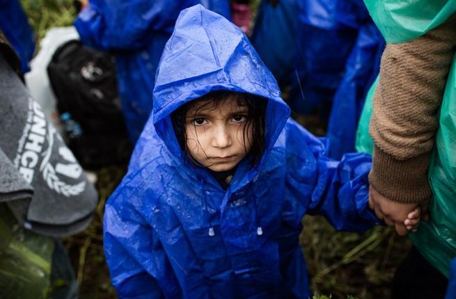 A child waits in the rain on the Serbia Croatia border