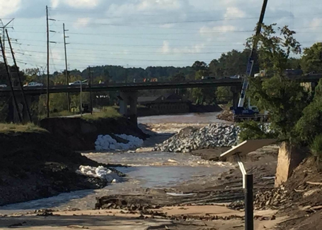 A crane is dropping sandbags into the Columbia Canal to create a dam