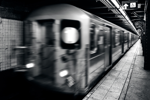 A New York City 1 Train arrives at a subway stop