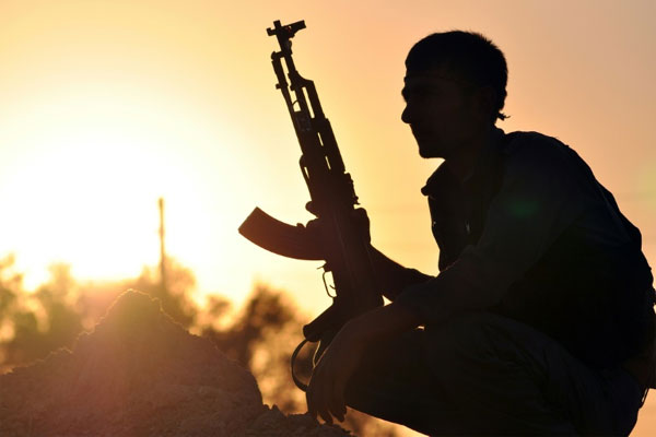 A fighter from the Kurdish People Protection Unit guards a checkpoint in the Syrian town of Ain Issi