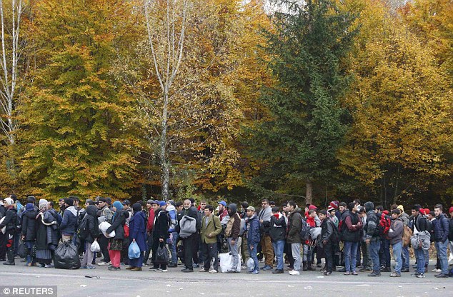 A group of migrants waits to be registered as they prepare to cross the border into Spielfeld in Austria from the village of Sentilj Slovenia