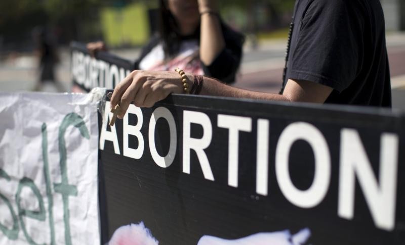 A pro-life activist holds a rosary while protesting outside City Hall in Los Angeles