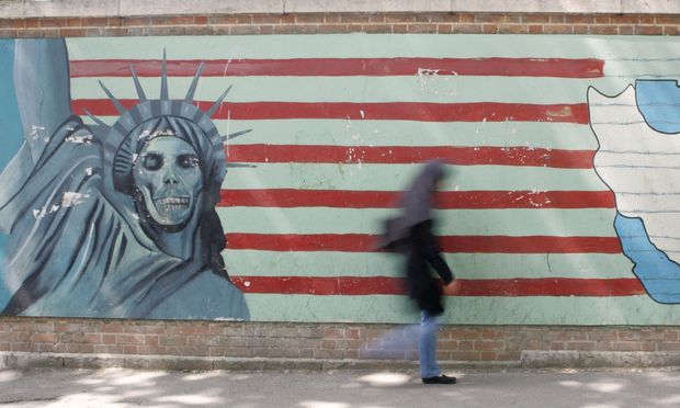 A woman passes by a mural on the wall of the former U.S. embassy in Teheran