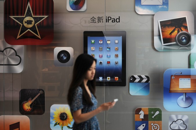 A woman walks by an Apple store in Shanghai