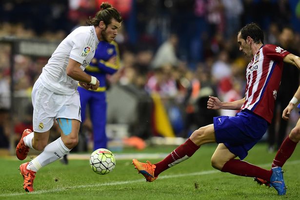 Gareth Bale vies with Diego Godin