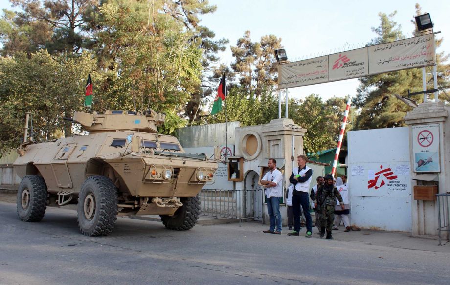 Doctors Without Borders staff stand as an Afghan National Army vehicle guards at the gate of its hospital after U.S. troops left the area in Kunduz Afghanistan on Thursday