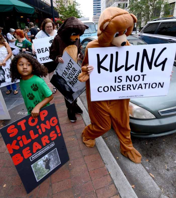 Activists dressed in bear costumes Friday to protest the state's bear hunt at The Jacksonville Landing. AP