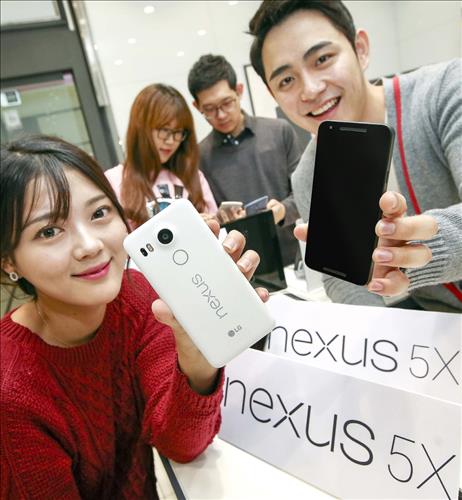 Models pose as they hold up Google Inc.'s new Nexus 5X manufactured by LG Electronics Inc. in Seoul on Oct. 19 2015