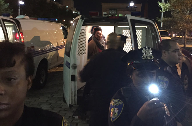 Protesters are placed into a van by police early Thursday Oct. 15 2015 in Baltimore. Police officers have converged on Baltimore's City Hall where protesters could be seen being led away to vans and vehicles after an hourslong occupation of the buildin