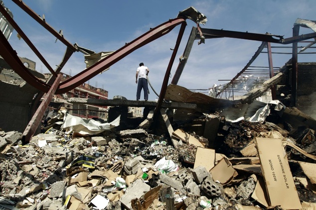 A Yemeni man stands amid the rubble of a food storage warehouse after it was targeted by air strikes carried out by the Saudi-led coalition in the capital Sa