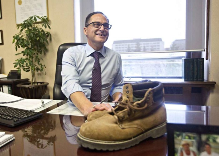 Alberta Finance Minister Joe Ceci displays his late father's work boots as part of a pre-budget