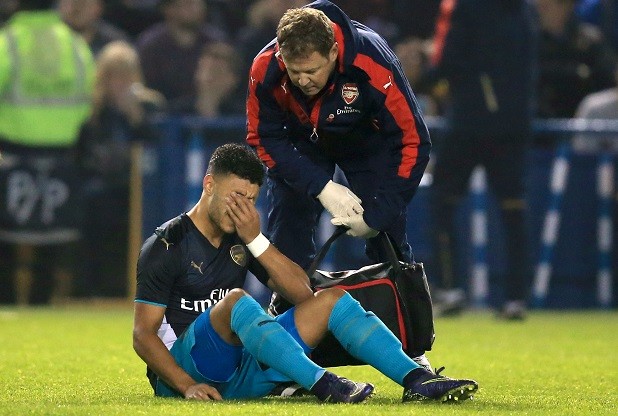 Alex Oxlade Chamberlain speaks with the physio as he sits injured during the Capital One Cup Fourth Round match at Hillsborough