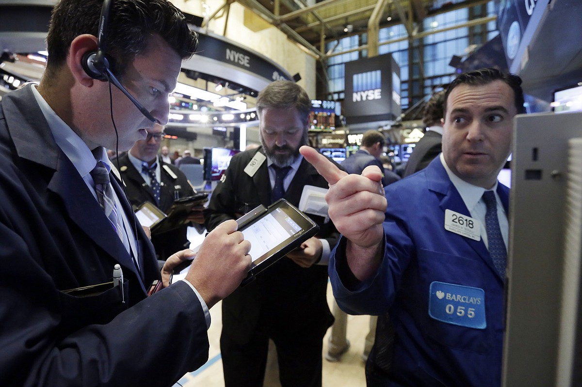 Specialist James Sciulli right works with traders on the floor of the New York Stock Exchange Friday Oct. 23 2015. Technology shares are surging in early trading after several big-name companies reported big earnings gains