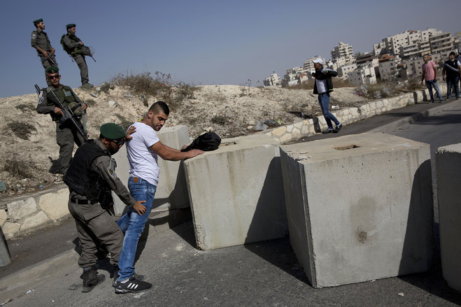 Israeli border police search a Palestinian next to newly placed concrete blocks in an east Jerusalem neighborhood. An Israeli proposal that would potentially strip tens of thousands of Palestinians in Je