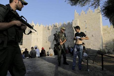 An Israeli policeman checked a young Palestinian man at the Damascus Gate in Jerusalem’s Old City on Saturday