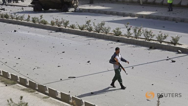 An Afghan security personnel keeps watch at the site of a suicide car bomb blast in Kabul Afghanistan