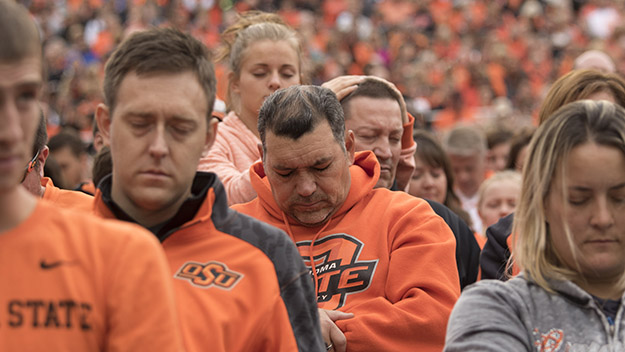 STILLWATER OK- OCTOBER 24 Oklahoma State football fans observe a moment of silence for the people killed by a car that crashed into the homecoming parade during the a NCAA college football game against the Kansas Jayhawks at the Boone Pickens Stadium