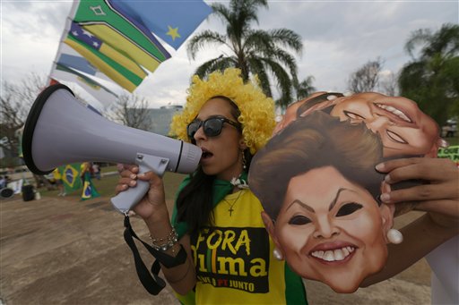 A demonstrator shouts slogans against Brazilian President Dilma Rousseff with a bullhorn outside the headquarters of the the Federal Court of Accounts in Brasilia Brazil Wednesday Oct. 7 2015. The Court decides today whether to approve the government