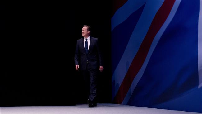 British Prime Minister David Cameron arrives on stage to deliver a speech to delegates on the final day of the annual Conservative Party Conference in Manchester