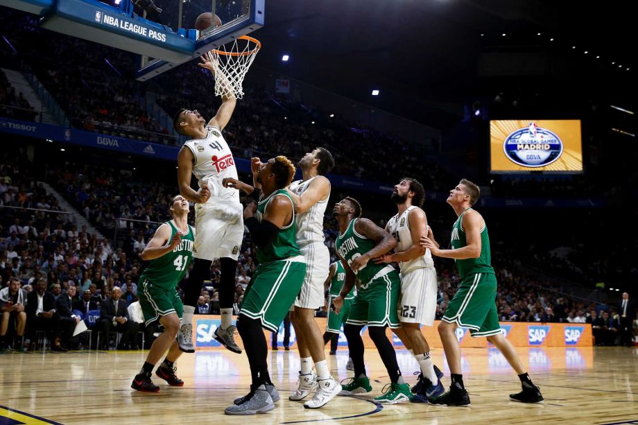 Real Madrid's Guillermo Hernangomez left drives the ball to the basket in presence of Celtic's Jared Sullinger center during a friendly basketball match between Real Madrid and Boston Celtics at the Barclaycard Centre sport arena in Madrid Spain Thu