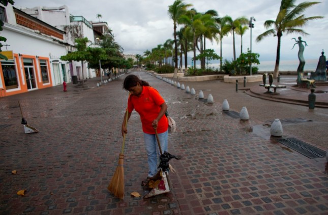 A city cleaner sweeps normal leaves and debris from a seafront walkway the morning after Hurricane Patricia passed further south sparing Puerto Vallarta Mexico Saturday Oct. 24 2015. The storm made landfall Friday evening on Mexico's Pacific coast