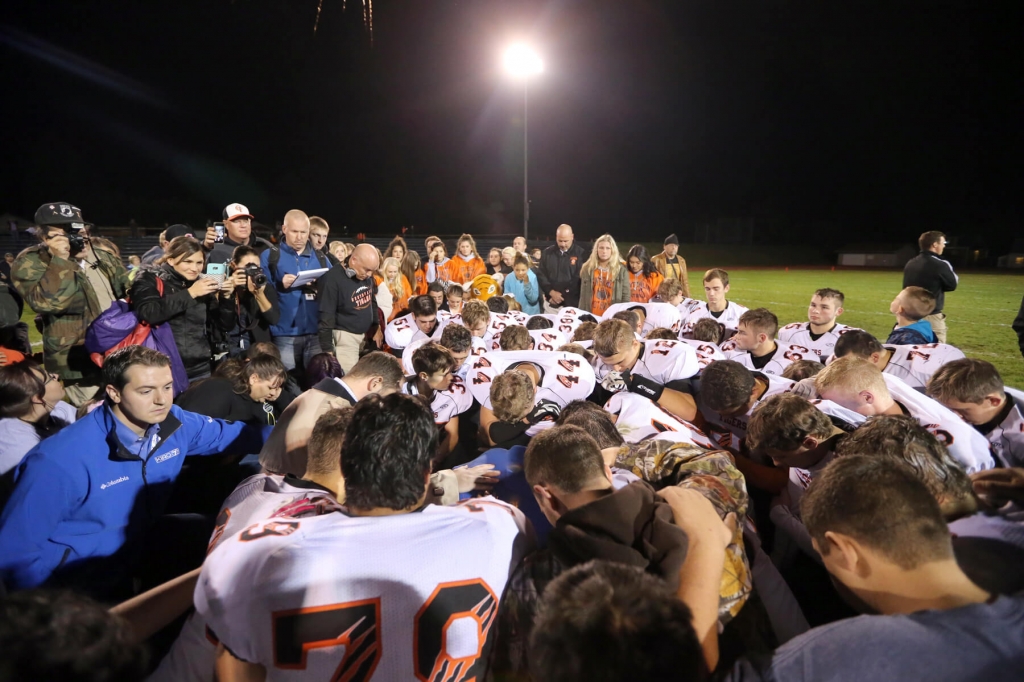 Bremerton assistant football coach Joe Kennedy is surrounded by Centralia players after they took a knee with him and prayed after their game against Bremerton in Bremerton Wash