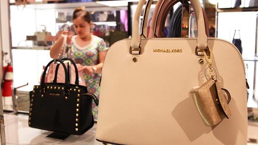 Shopper looking at Michael Kors bags at Macy's in New York