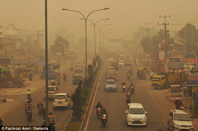 Desperate evacuees took to their motorbikes in a desperate attempt to escape the acrid haze and choking pollution caused by thousands of forest fires in Indonesia