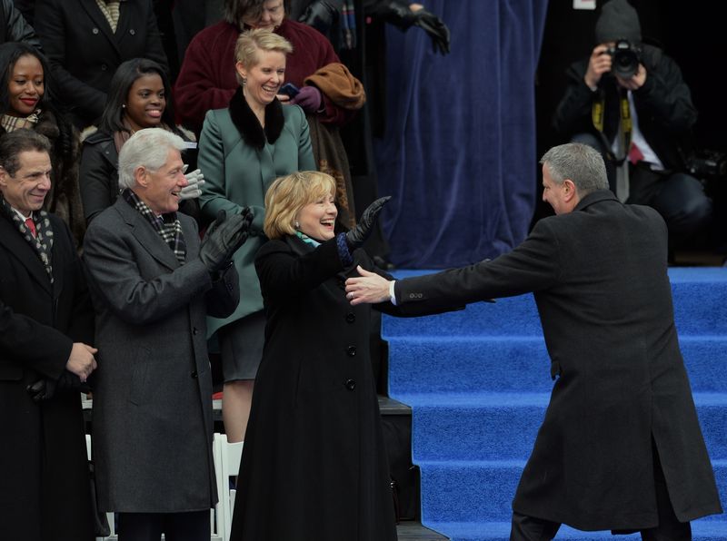 Newly sworn in New York City Mayor Bill de Blasio walks to hug Hillary Rodham Clinton on the steps of City Hall in Lower Manhattan