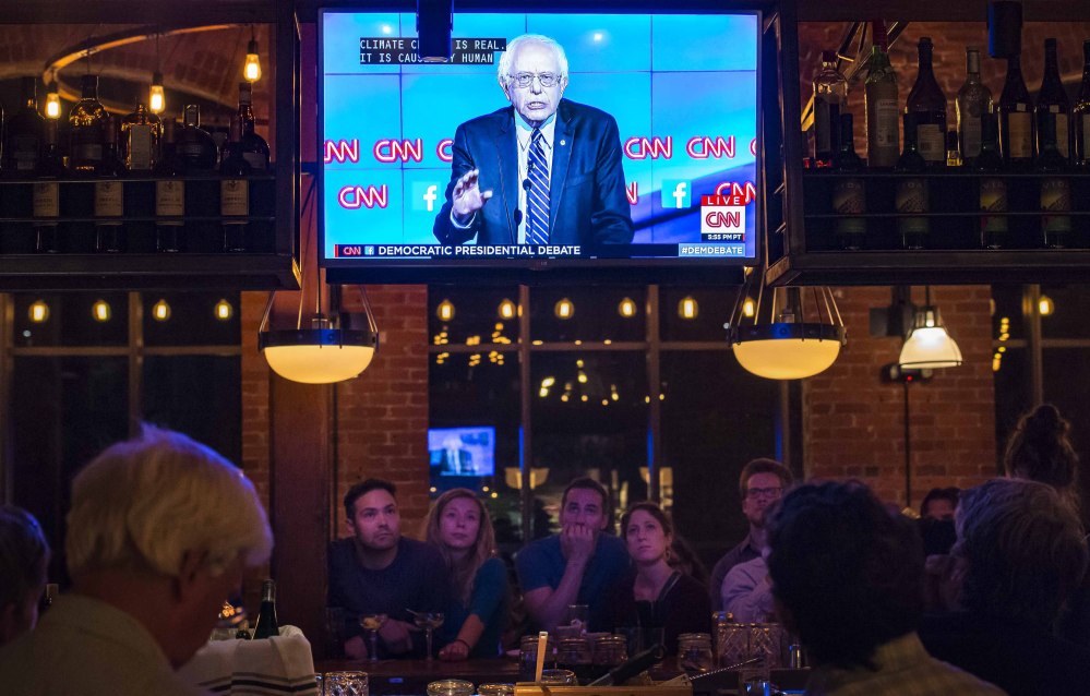 People watch the Democratic presidential debate from Las Vegas at a restaurant in Winooski Vt. The Vermont Democratic Party sponsored the viewing party. Vermont Sen. Bernie Sanders on the television screen was challenged often by Hillary Clinton