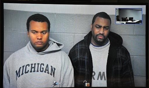 In this image taken from video provided by the 36th District Court Detroit police officers Charles Lynem 28 left and Chancellor Searcy 31 are arraigned via video conference Tuesday Oct. 27 2015 in Detroit. The two officers have been charged in