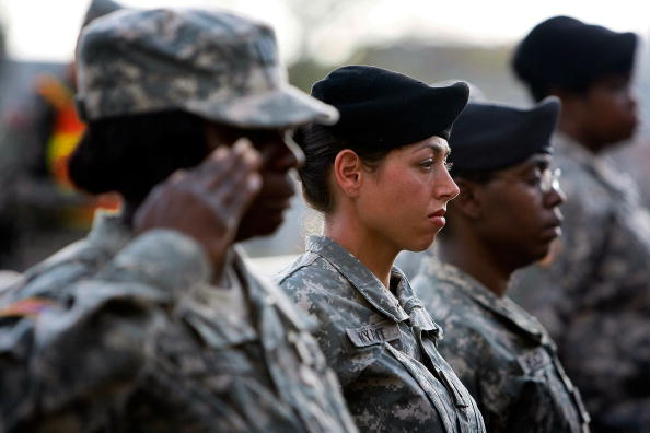 Army soldiers stand together as they salute during the memorial service