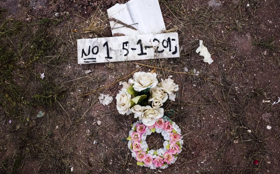 Flowers are placed on the grave of an unidentified migrant who drowned at sea during an attempt to cross a part of the Aegean Sea from the Turkish coast at the Saint Panteleimon cemetery of Mytilene on the Greek island of Lesvos October 7