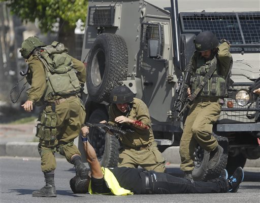 Israeli soldier runs to help another who was just stabbed by a Palestinian seen on the ground holding a knife during clashes in Hebron West Bank. The clashes between Israelis and Palestinians in the