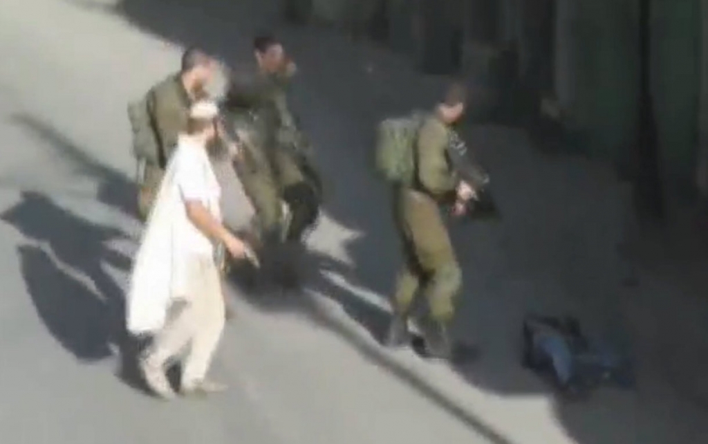 A Jewish settler holding his pistol after he shot and killed a Palestinian man is seen in this still image taken from a video shot by Youth Against Settlements. 3 Palestinians were shot dead trying to stab Israelis in east Jerusalem and the West Bank