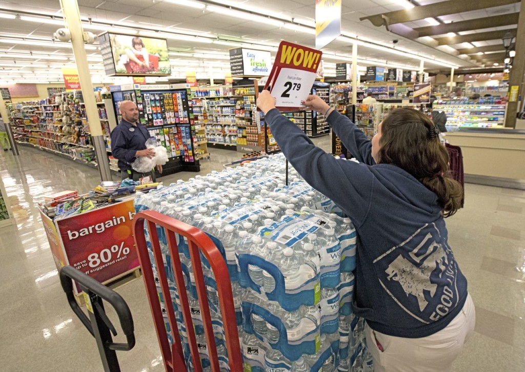 Kristen Nice readies cases of bottled water for sale at the Food Lion in Newport News Va. Thursday as the grocer brings in extra people for checkout and stocking and customers stock up on food essentials ahead of Hurricane Joaquin. Adrin Snider  The Dail