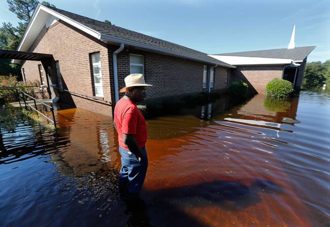 Matt Desjardins of Waccamaw Lake Drive describes the level of water in his home to neighbors in Conway South Carolina