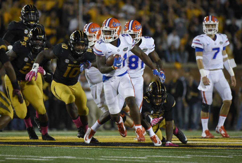 Running back Kelvin Taylor #21 of the Florida Gators finds room against the Missouri Tigers defense in the second quarter at Memorial Stadium